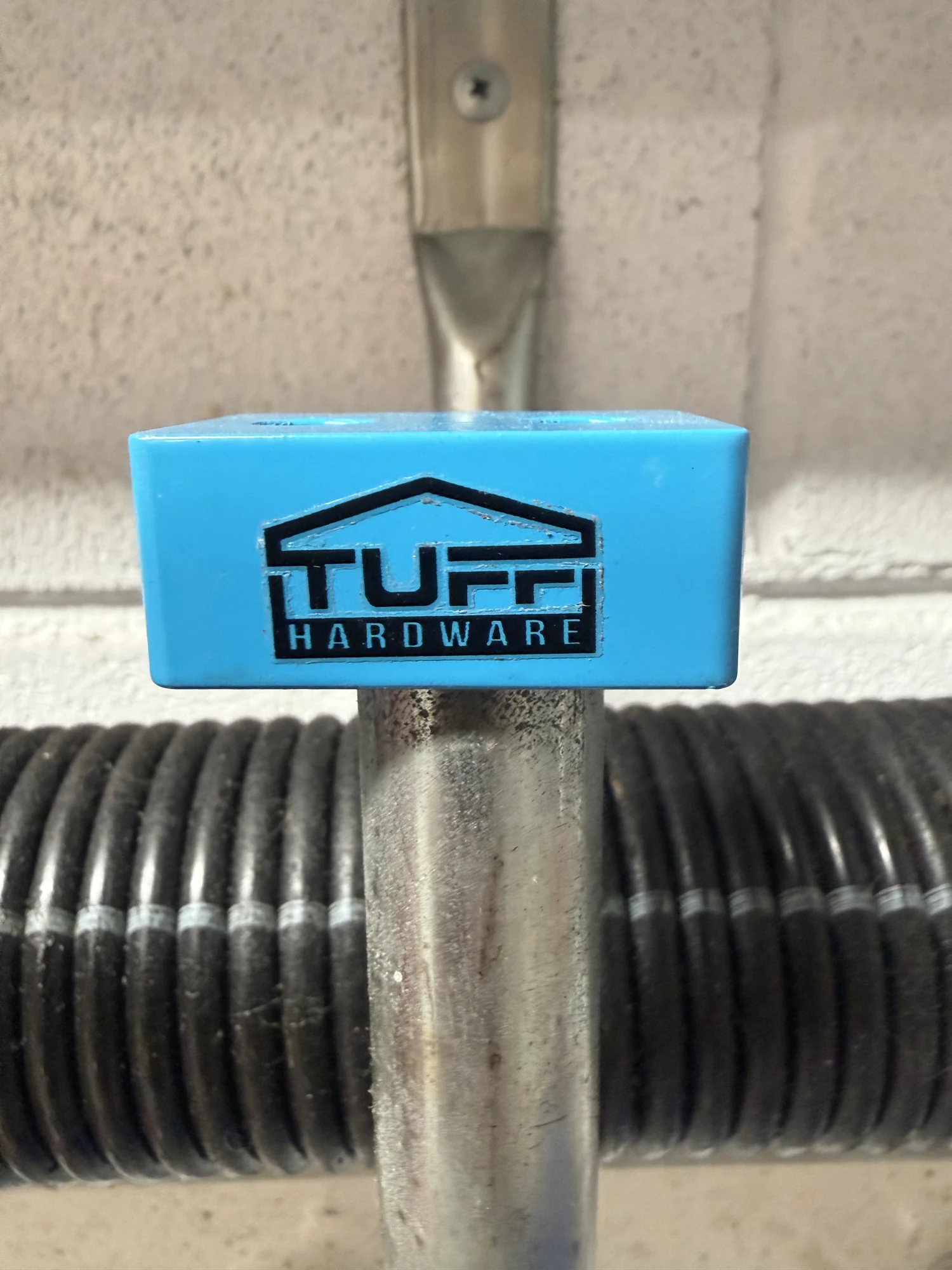 Tuff Hardware winding bar holder fitted near a garage door spring